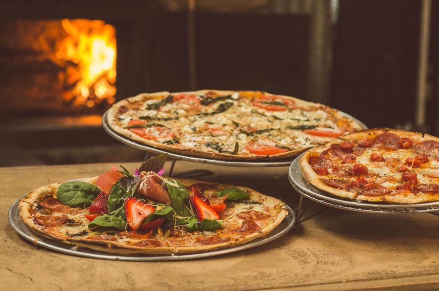 Tres pizzas artesanales cerca del horno de leña